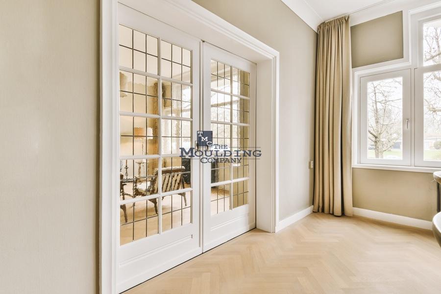 Door casing and window trim installed in a finished room showing matching trim profiles