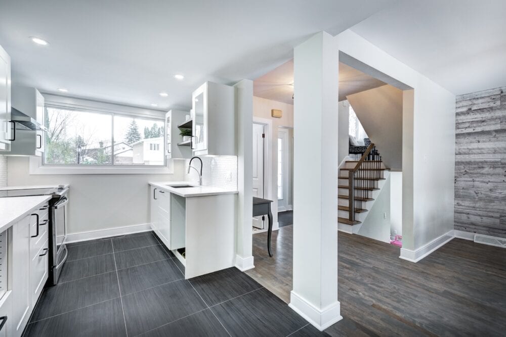 Elegant kitchen with white cabinets, dark flooring, and decorative molding accents.